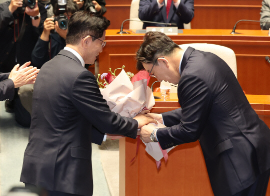 김문수 국민의힘 대선 후보가 9일 국회에서 열린 의원총회에서 권성동 원내대표로부터 꽃다발을 받고 있다. [연합뉴스]